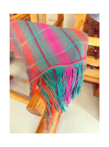 A textile woven scarf with vibrant colours.